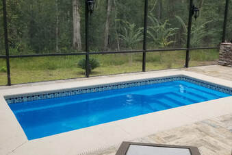 a fiberglass plunge pool inside a screened in porch area